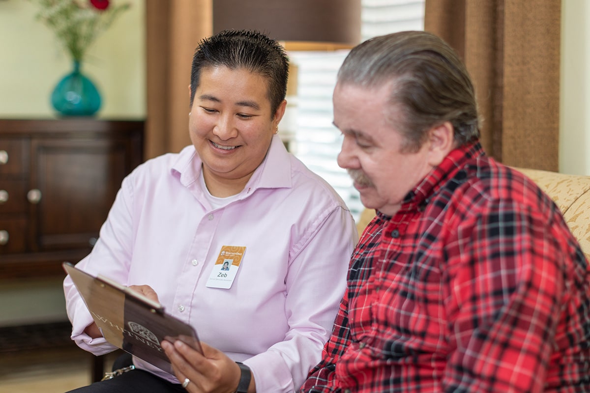 An employee talking to a resident at Whitney Oaks