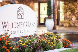 The Whitney Oaks front entrance sign with flowers