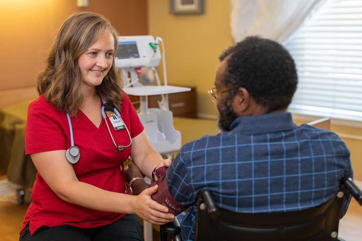 A nurse assisting a resident at Whitney Oaks