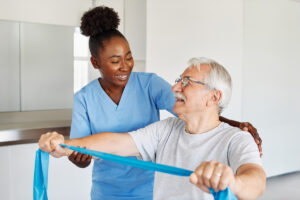 physical therapist helping post surgery patient with exercise band